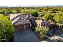 Aerial view of desert home and golf course with a large driveway and a two-car garage at 23014 N 52Nd St, Phoenix, AZ 85054