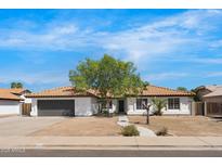 Charming single-story home featuring a tile roof and a mature tree in the front yard at 2640 E Mallory St, Mesa, AZ 85213