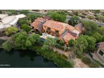 An aerial view of a stately residence with a pond and mature landscaping, offering privacy and scenic views at 27050 N 103Rd St, Scottsdale, AZ 85262