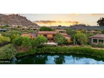 A beautiful estate home with mature landscaping overlooking a community pond and views of the surrounding mountains at 27050 N 103Rd St, Scottsdale, AZ 85262
