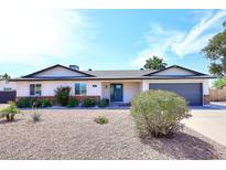 Charming single-story home featuring a low-maintenance desert landscape and a neutral-colored exterior at 325 W San Angelo St, Gilbert, AZ 85233