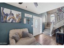 Cozy living room featuring comfortable seating and stylish decor with a staircase to the upper floor at 3732 W Bluefield Ave, Glendale, AZ 85308