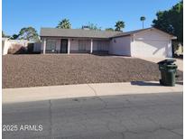 Single-story home with a two-car garage and low-maintenance landscaping in front at 3828 W Crocus Dr, Phoenix, AZ 85053