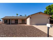 Charming home with a two-car garage, neutral colors and low-maintenance gravel landscaping in front at 3828 W Crocus Dr, Phoenix, AZ 85053