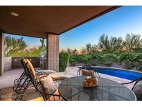 Inviting outdoor patio area with lounge chairs, grill and sparkling pool surrounded by lush desert landscaping at 39541 N 107Th Way, Scottsdale, AZ 85262