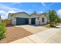 Charming single-story home featuring a three car garage, stone accents, and desert landscaping at 4619 N 179Th Dr, Goodyear, AZ 85395