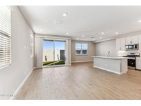 Bright living space with wood-look tile flooring, recessed lighting, and sliding door to backyard at 5856 E Covey Ln, Phoenix, AZ 85054