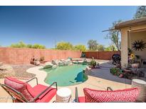 Inviting backyard pool with rock accents and a serene desert landscape, perfect for relaxation and outdoor enjoyment at 16924 W Stevenage St, Surprise, AZ 85374
