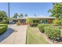 Charming brick home with a well-manicured front yard and covered parking at 1945 E Solano Dr, Phoenix, AZ 85016