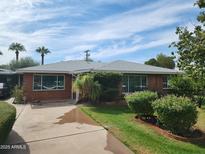 Charming single-story brick home with well-maintained landscaping and a spacious driveway at 1945 E Solano Dr, Phoenix, AZ 85016
