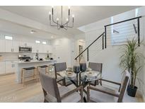 Bright dining area with a glass table, modern chandelier, and view of the kitchen island at 25925 N 53Rd Dr, Phoenix, AZ 85083