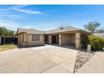 Charming single-story home featuring a spacious driveway and covered parking area at 4165 E Huntington Dr, Phoenix, AZ 85040