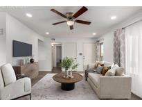 Bright living room featuring a ceiling fan, modern furniture and stylish decor and front door at 5221 E Tunder Cir, Phoenix, AZ 85044