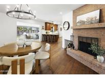 Open concept dining area featuring brick fireplace, wood table and chairs, and modern lighting at 613 E Vista Ave, Phoenix, AZ 85020