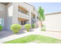 Three-story condo building with well-maintained landscaping and exterior stairs to upper units at 7009 E Acoma Dr # 1160, Scottsdale, AZ 85254
