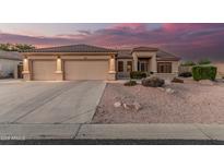 Charming home featuring a spacious three-car garage, tile roof, and desert landscaping at 8220 W Mariposa Grande Ln, Peoria, AZ 85383