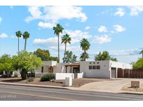 Charming single-story home with palm trees and desert landscaping providing excellent curb appeal at 14401 N Coral Gables Dr, Phoenix, AZ 85023