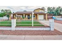 Charming single-Gathering home with a well-maintained lawn, decorative front fence, and covered entryway at 3121 W Greenway Rd, Phoenix, AZ 85053