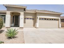Charming single-story home featuring a spacious three car garage, front door and desert landscaping at 1024 W Ayrshire Trl, San Tan Valley, AZ 85143