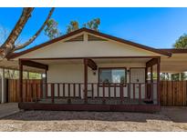 Charming house featuring a welcoming porch and adjacent carport providing convenient covered parking at 115 S Stardust Ln, Apache Junction, AZ 85120