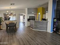 Spacious living space featuring wood flooring, modern lighting, and open floor plan at 11760 N 153Rd Ave, Surprise, AZ 85379