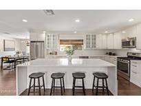 Spacious kitchen features white cabinets, a center island with seating, and stainless steel appliances at 1431 E San Juan Ave, Phoenix, AZ 85014