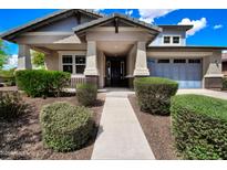 Charming home featuring a well-manicured lawn, covered porch, and an attached two car garage at 14770 W Voltaire St, Surprise, AZ 85379