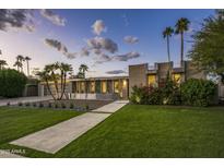 Charming exterior view of home with manicured lawn, mature landscaping, and a long driveway leading to a two-car garage at 20 W Canterbury Ln, Phoenix, AZ 85023