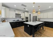 A modern kitchen features an island, stainless steel appliances, pendant lighting, and white subway tile backsplash at 20483 E Mockingbird Dr, Queen Creek, AZ 85142