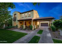 Charming two-story home with a tile roof, covered porch, and beautifully landscaped front yard at 20791 W Main St, Buckeye, AZ 85396