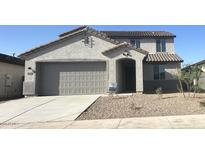 Charming two-story home featuring a neutral color scheme, landscaped front yard, and a two-car garage at 25348 W Bowker St, Buckeye, AZ 85326