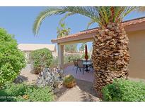 Outdoor patio with table, chairs and lush desert landscaping perfect for entertaining or relaxing in the Arizona sun at 3928 N 151St Ave, Goodyear, AZ 85395