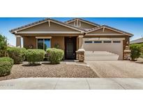 Charming single-story home with a well-manicured front yard, a stone-accented facade, and a two-car garage on a sunny day at 531 S 198Th Ave, Buckeye, AZ 85326