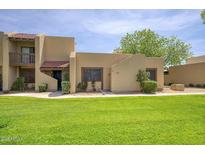 Inviting home featuring a well-manicured lawn and charming architectural details on a sunny day at 5807 W Acoma Dr, Glendale, AZ 85306