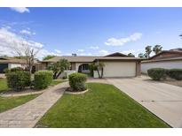Charming single-story home with manicured lawn, mature trees, and a paved walkway leading to the front door at 6027 E Spring Rd, Scottsdale, AZ 85254