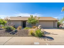 Charming home featuring desert landscaping, a two-car garage, and a welcoming front entrance at 6333 W Banff Ln, Glendale, AZ 85306