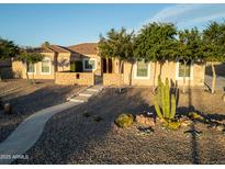Charming single-story home with desert landscaping, mature trees, and a quaint stone entrance at 7969 S 172Nd St, Queen Creek, AZ 85142