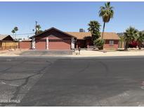 Charming single-story home featuring a two car garage, desert landscaping, and mature palm trees at 8609 S 16Th St, Phoenix, AZ 85042