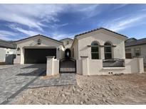 Charming single-story home with a two-car garage, stone driveway, and beautiful wrought-iron gate at 1185 E Gleneagle Dr, Chandler, AZ 85249