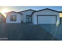 Inviting single-story home showcasing a clean white facade, black trim, and a well-kept gravel front yard at 15864 S Cherry Hills Dr, Arizona City, AZ 85123