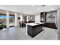 Modern kitchen with stainless appliances, an island with a sink, and an open-concept layout to the dining area at 3549 W Magellan Dr, Anthem, AZ 85086