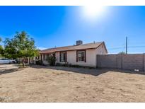 Exterior of a single-story home with a spacious yard and a partial block wall at 7357 W Cheryl Dr, Peoria, AZ 85345