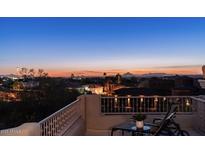 Enjoy spectacular sunset views from this home's private balcony overlooking the city and distant mountains at twilight at 4332 N Santiago Cir, Mesa, AZ 85215