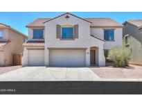Inviting two-story home featuring a three-car garage, desert landscaping, and a neutral color palette at 43601 W Cowpath Rd, Maricopa, AZ 85138