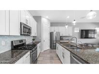 Updated kitchen features granite countertops, stainless steel appliances, and white cabinets at 1104 E Tekoa Ave, Gilbert, AZ 85298
