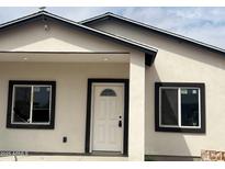 Charming home featuring a white front door, dark framed windows and a security camera at 1519 N Etta St, Casa Grande, AZ 85122