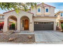Charming two-story home with a spacious two-car garage and an arched entryway, creating a welcoming curb appeal at 1550 S Chaparral Blvd, Gilbert, AZ 85296