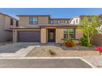 Charming two-story home featuring a two-car garage and landscaped front yard with stone accents at 17736 W Cassia Way, Goodyear, AZ 85338