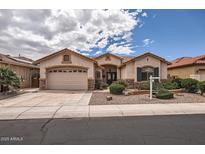 Beautiful single-Gathering home featuring a three-car garage and manicured desert landscaping at 17951 W Sammy Way, Surprise, AZ 85374