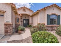 Charming home entrance with a walkway and mature desert landscaping at 17951 W Sammy Way, Surprise, AZ 85374